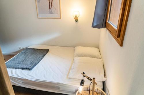 - un petit lit dans une petite chambre avec fenêtre dans l'établissement Résidence Le Parc Des Airelles - Adorable appartement avec accès direct aux pistes MAE-4221, aux Orres