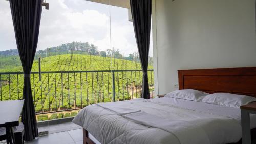 - une chambre avec un lit et une vue sur un vignoble dans l'établissement Zen Vista, à Valparai