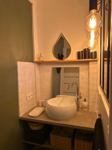 La salle de bains est pourvue d'un lavabo et d'un miroir sur un comptoir. dans l'établissement Studio Cosy rue Sainte/St Victor, à Marseille