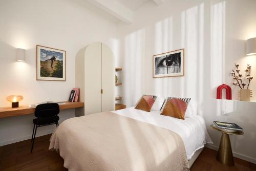 une chambre avec un lit et un bureau avec une chaise dans l'établissement Art Deco Loft - 2BR and 2BA near Canal Saint Martin, à Paris