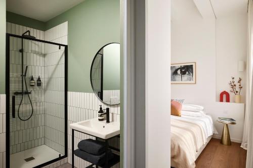 une salle de bain avec une douche, un lit et un lavabo dans l'établissement Art Deco Loft - 2BR and 2BA near Canal Saint Martin, à Paris
