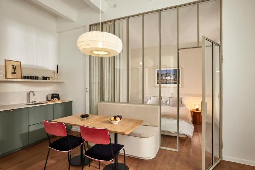 une pièce avec une table, des chaises et un lit dans l'établissement Art Deco Loft - 2BR and 2BA near Canal Saint Martin, à Paris