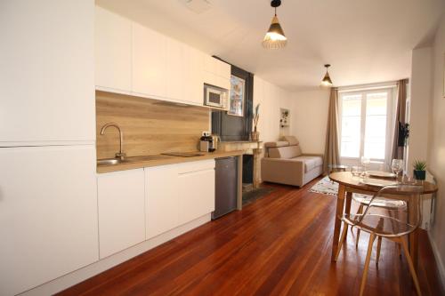 une cuisine avec des armoires blanches et une table dans une pièce dans l'établissement Studio coté belvédère, à Thonon-les-Bains