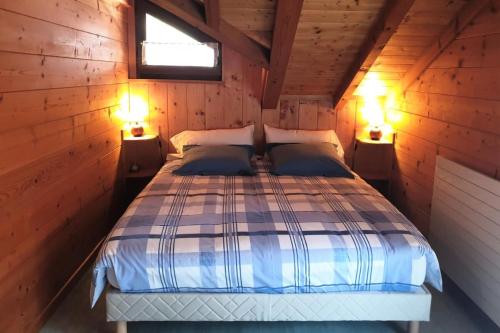 een slaapkamer met een bed in een houten hut bij Chalet Cosy - Chalets pour 5 Personnes 111 in Morzine