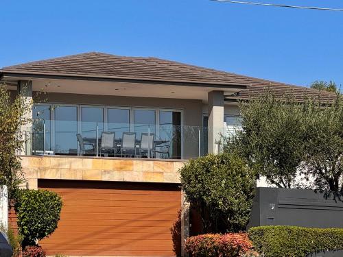 a house with a deck with chairs in it at Luxurious Comfort with Bay Views in Frankston South