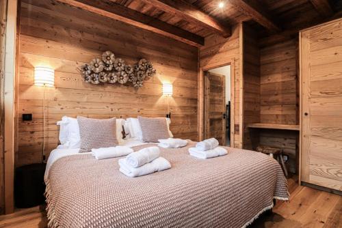 een slaapkamer met een bed met handdoeken erop bij Résidence Nanook - Chalets pour 10 Personnes 931 in Morzine