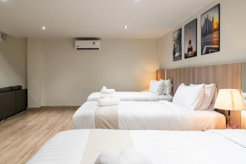 a hotel room with two beds and a television at indigo Hotel Hatyai in Ban Kohong