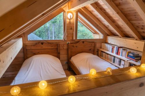 two beds in the attic of a tiny house at Résidence Pramouton - Chalets pour 9 Personnes 591 in Le Mélézet