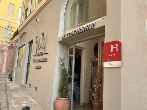 un bâtiment avec un panneau sur son côté dans l'établissement Hôtel Posta Vecchia, à Bastia