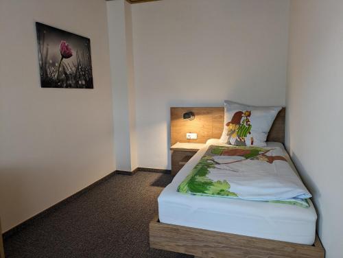a small bedroom with a bed and a desk at Lauras Landhauspension in Medebach