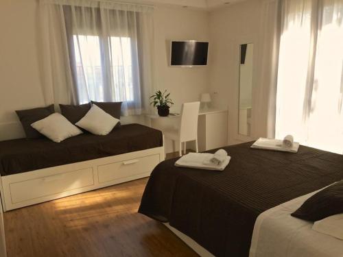 a bedroom with two beds and a desk with a mirror at Boutique Hotel e Spa Città Bianca in Pescara