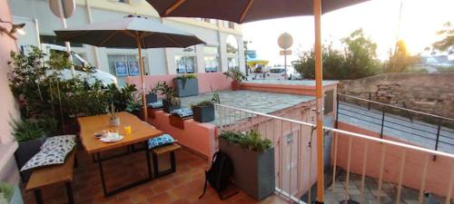 a patio with a table and an umbrella at Hôtel Posta Vecchia in Bastia