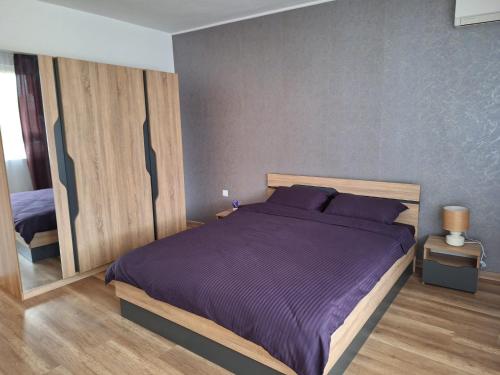 a bedroom with a large bed with purple sheets at HomeViza in Yambol