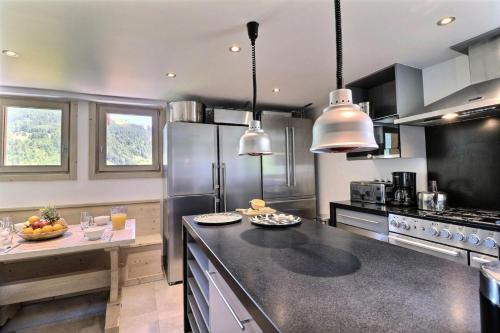 une cuisine avec des appareils en acier inoxydable et un comptoir dans l'établissement Résidence Explorer Meleze - Chalet Explorer - 14 Personnes - Les Gets MAE-3781, aux Gets