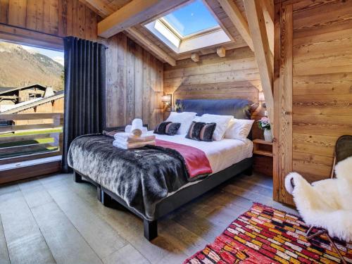 une chambre avec un lit dans une pièce avec une fenêtre dans l'établissement Chalet Ressource - Chalet Ressource - 13 Personnes - Morzine MAE-3821, à Morzine