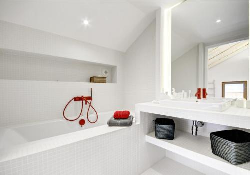 une salle de bain blanche avec une baignoire et un lavabo dans l'établissement Résidence Villa Solaire - Chalet Villa Solaire - 14 Personnes - Morzine MAE-3761, à Morzine