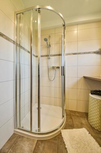 a shower with a glass door in a bathroom at Miller Appartements in Sankt Veit im Pongau