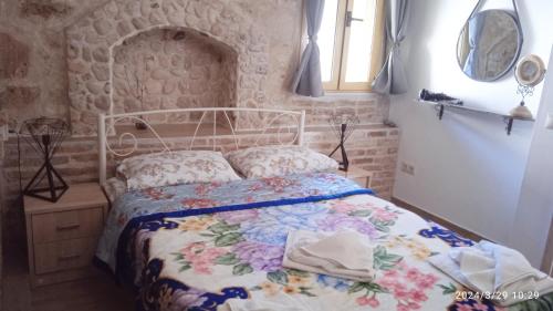 a bedroom with a bed with a floral bedspread at HARI'S NEST CORFU in Marathias