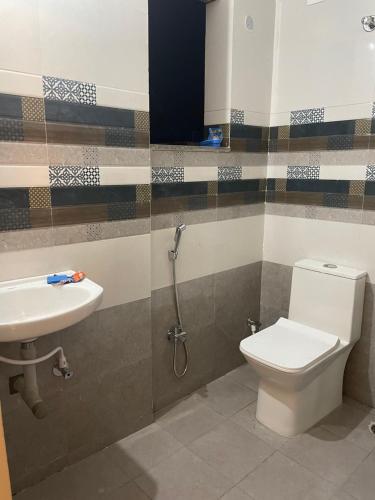 a bathroom with a toilet and a sink at Hotel Kings Inn in Nagpur