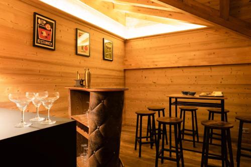 - un bar avec tabourets dans une pièce dotée de murs en bois dans l'établissement Résidence Les Rosiers - Chalet Rosiers - 10 Personnes - Montriond MAE-3901, à Montriond