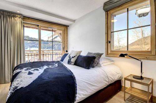 une chambre avec un grand lit et une fenêtre dans l'établissement Résidence Panoramix - Appartement Panoramix - 6 Personnes - Morzine MAE-4041, à Morzine