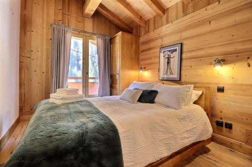 une chambre avec un lit dans une cabane en rondins dans l'établissement Résidence Eveleen - Chalet Eveleen - 8 Personnes - Morzine MAE-3971, à Morzine