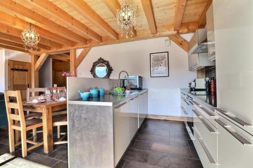 une cuisine avec une table et une salle à manger dans l'établissement Résidence Les Hauts Forts De La Croix - Appartement Blue Olive - 8 Personnes - Morzine MAE-3981, à Morzine
