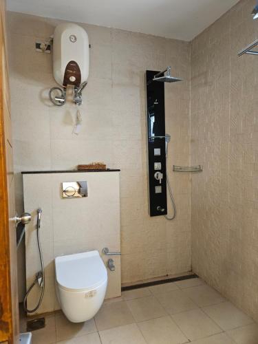 a bathroom with a toilet and a phone on the wall at Villa in Vrindavan, Hare Krishna M (ISKCON) campus in Vrindāvan