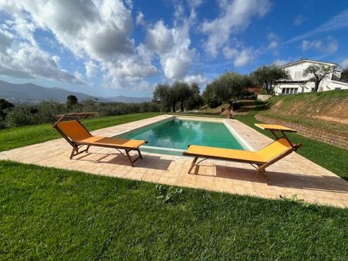 a swimming pool with two chairs next to at Casa Oro in Montecarlo