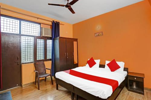 um quarto com uma cama e uma cadeira em OYO Prince Residency em Greater Noida