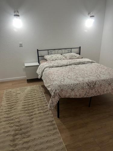 um quarto com uma cama e um tapete e duas luzes em Appartement de vacances em Fillinges