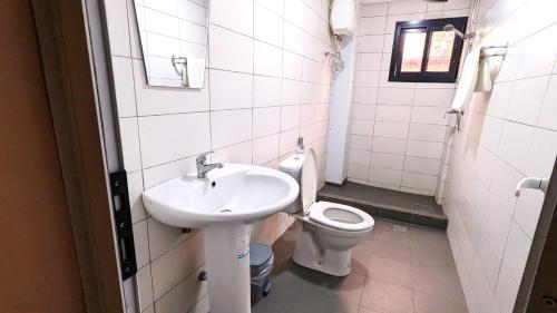 La salle de bains est pourvue d'un lavabo et de toilettes. dans l'établissement ALICIA HOTEL, à Douala