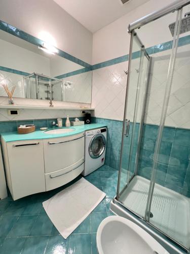 ein Bad mit einer Dusche und einer Waschmaschine in der Unterkunft Bali Loft Savona Albissola in Savona