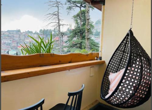 a hammock hanging in a room with a window at Hotel Willow Banks Shimla in Shimla