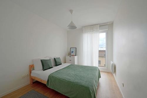 een witte slaapkamer met een bed en een raam bij 3bedrooms beautiful and spacious appartment in Saint-Ouen