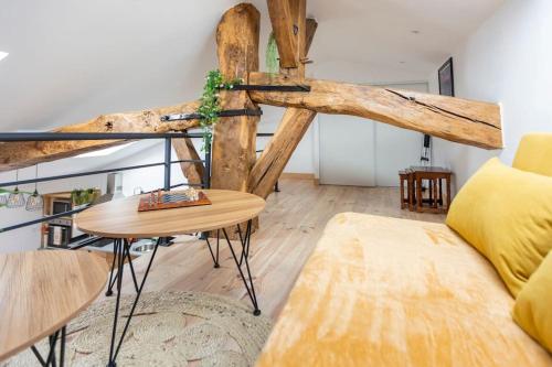 un salon avec un canapé et une table dans l'établissement Le nid de bois - Centre ville -Thermes-Center Parc, à Casteljaloux