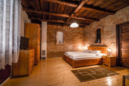 1 dormitorio con cama y pared de ladrillo en Kokaspajta Vendégház, en Kaposszekcső