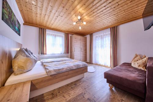 um quarto com uma cama e um sofá em Miller Appartements em Sankt Veit im Pongau
