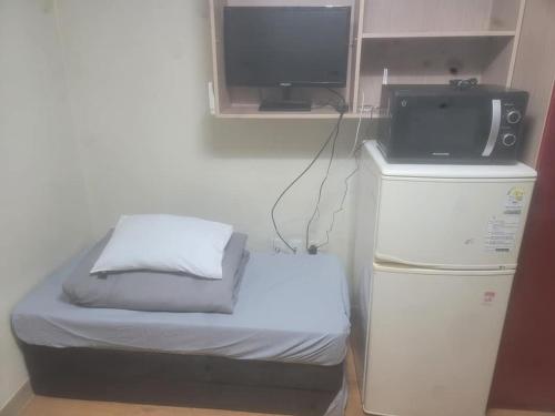 a room with a bed and a tv on top at Dongdaemun Studio in Seoul