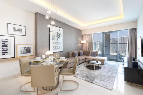 een woonkamer met een tafel en een bank bij Ultimate Stay / Luxurious Living at its Finest in Dubai