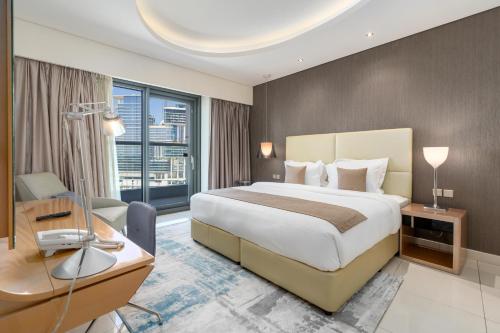 een hotelkamer met een groot bed, een bureau en een bureau bij Ultimate Stay / Luxurious Living at its Finest in Dubai