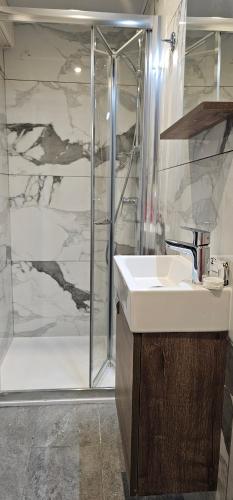 a bathroom with a sink and a shower at La Playa Hotel in Marsalforn