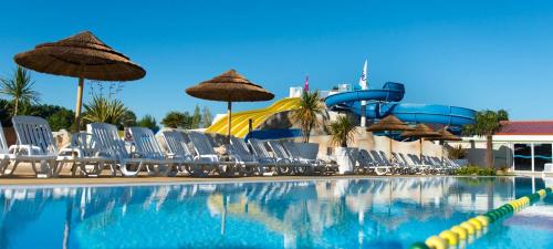 - une piscine avec des chaises et un toboggan dans l'établissement Mobil Home tout confort aux Charmettes, aux Mathes