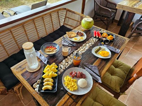 uma mesa de madeira com comida para o pequeno almoço em DK2 Resort - Hidden Natural Beach Spot - Direct Tours & Fast Internet em El Nido
