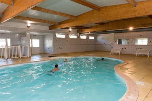 un groupe de personnes se baignant dans une grande piscine dans l'établissement Mobilhome 3 chambres, à Boofzheim
