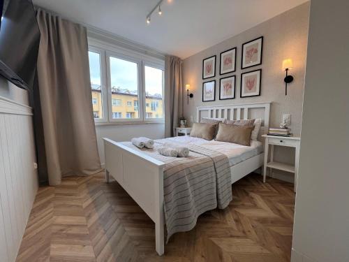 a bedroom with a white bed and a window at Apartament Czeremcha in Szczawnica