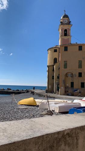 a group of surfboards on a beach with a clock tower at La Riva in Camogli