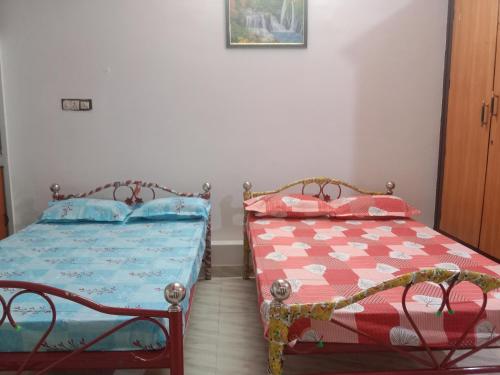 duas camas sentadas uma ao lado da outra num quarto em Bava guest house em Tiruvannamalai