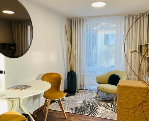 a living room with chairs and a table and a mirror at Hotel Schlossberg in Badenweiler