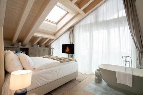 a bedroom with a large bed and a bath tub at Mirabeau Etoile in Zermatt